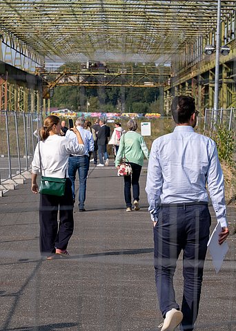 Eine Gruppe läuft über ein altes Industriegelände.