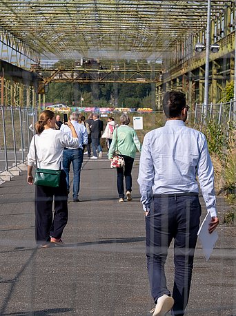 Eine Gruppe läuft über ein altes Industriegelände.