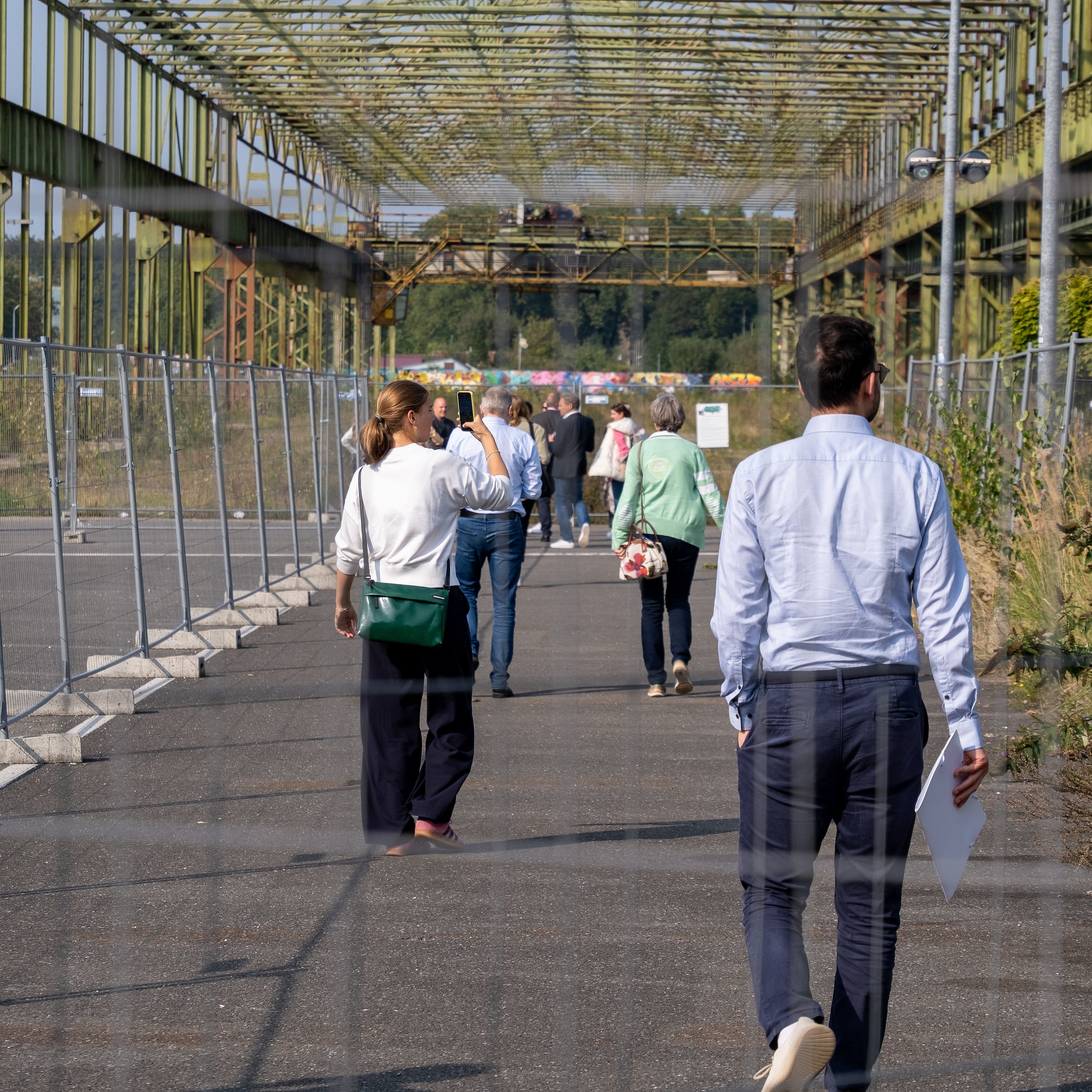 Eine Gruppe läuft über ein altes Industriegelände.