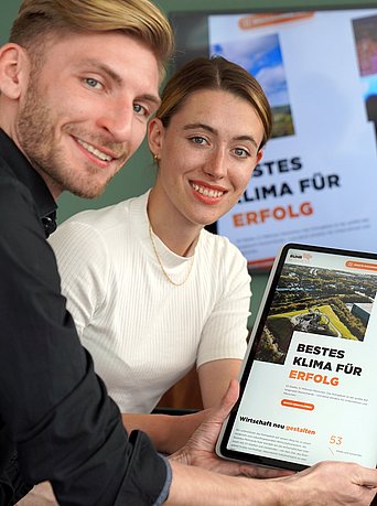 Das Projektteam um Lena Kaczmarczyk und Hendrik Weyers surft die neue Website der Business Metropole Ruhr an. Zu sehen sind zwei Fotos in einer Collage, wobei die brandneue Startseite mit der Aufschrift “bestes Klima für Erfolg” auf einem Tablet zu erkennen ist. 